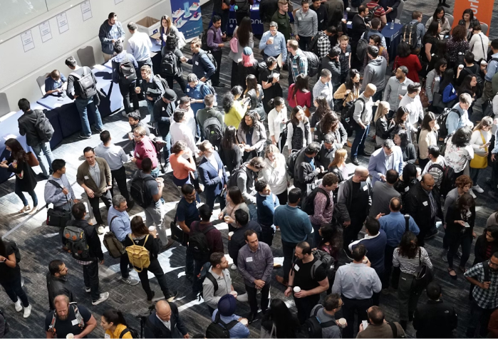 A large room of people at an academic event, shot from on high, from Product School on Unsplash